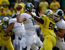 Michigan State quarterback gets a hard rush from Oregon linebacker Tony Washington.  Spartan loss to Oregon has apparently eliminated the Big 10 from playoff consideration.
